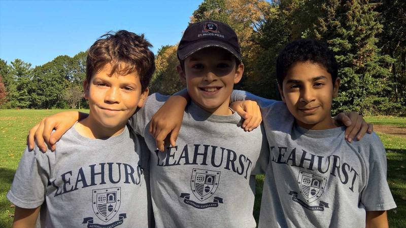 Picture of three students posing for a photo and wearing their athletics t-shirts