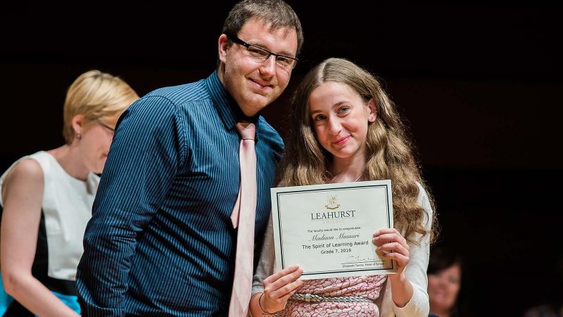 Picture of a teacher and a student with an award certificate