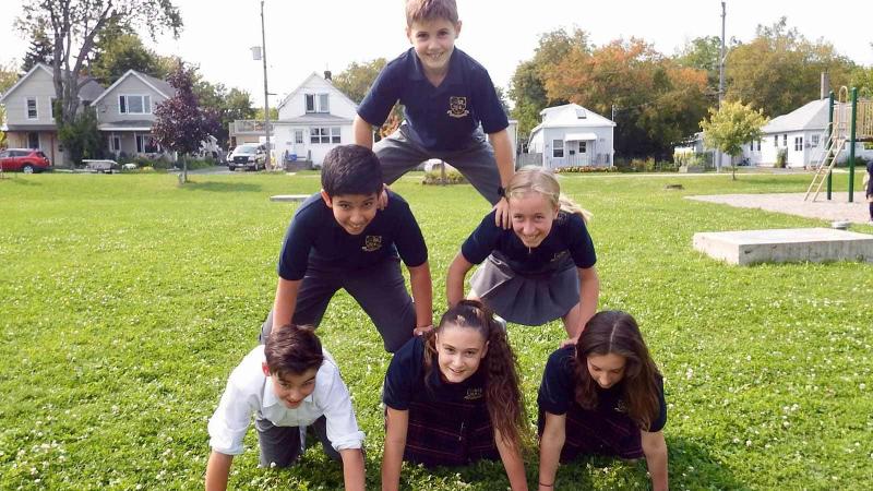 Picture of students doing a pyramid on grass
